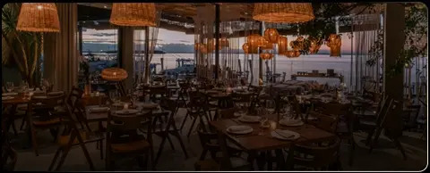 Interior de restaurante de Cancún con vistas a la laguna en el atardecer.