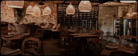 Rustic restaurant interior with wooden tables and a wine cellar