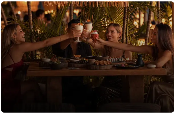 Group of people eating and toasting at Funky Geisha Asian Restaurant in Cancun