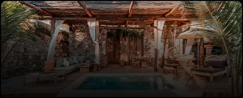 Rustic terrace with a small pool and wooden roof at a Tulum beach club