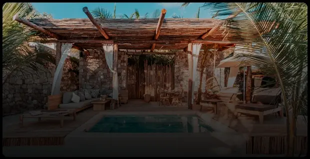 Rustic terrace with a small pool and wooden roof at a Tulum beach club