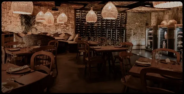 Rustic restaurant interior with wooden tables and a wine cellar